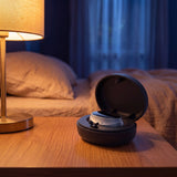 The RestWell device resting on its open charging case at dusk - Thumbnail 8